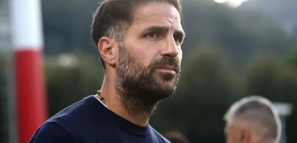 Homme avec barbe observant un entraînement de football