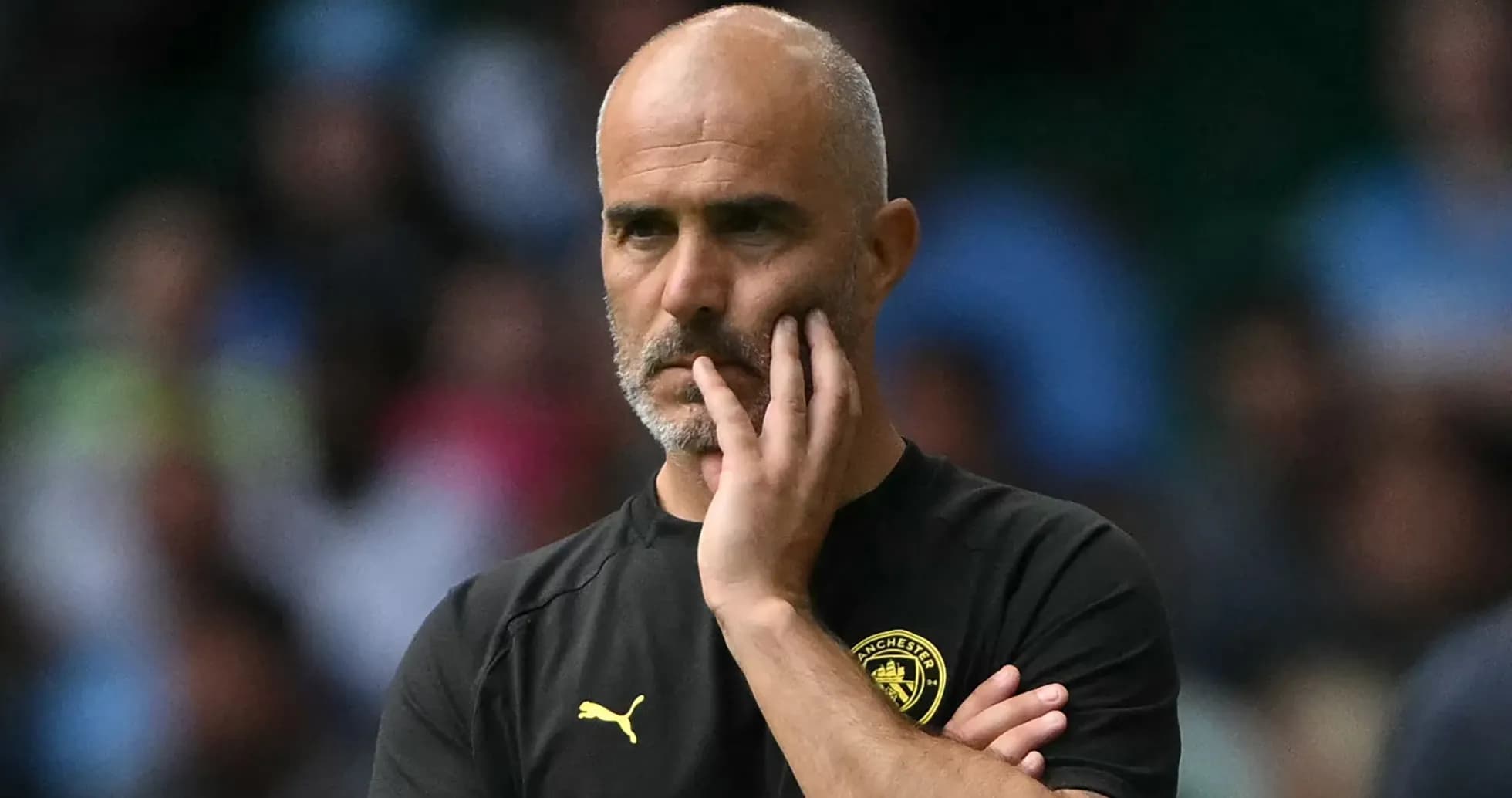 Entraîneur observant le match avec une expression pensive