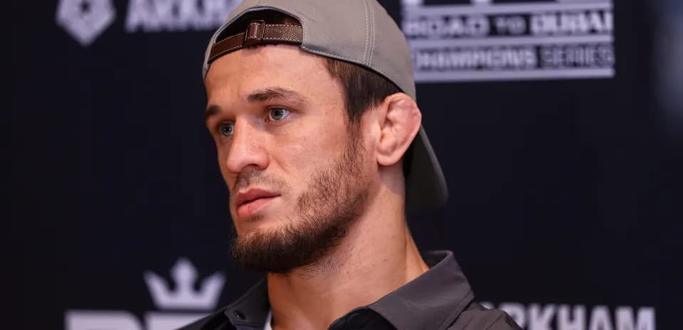 Athlete at press conference wearing cap and jacket