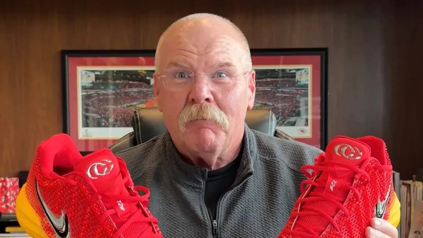 Person holding red sports shoes in office setting