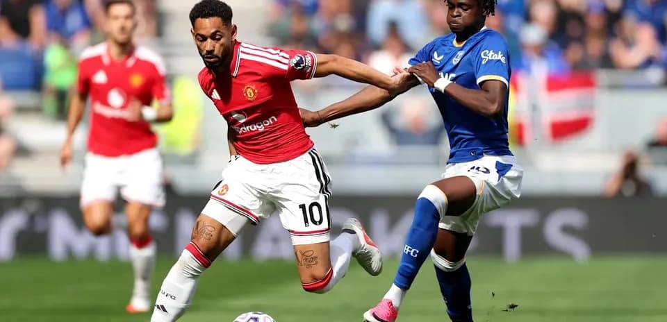Joueur de Manchester United dribblant sous pression d'Everton