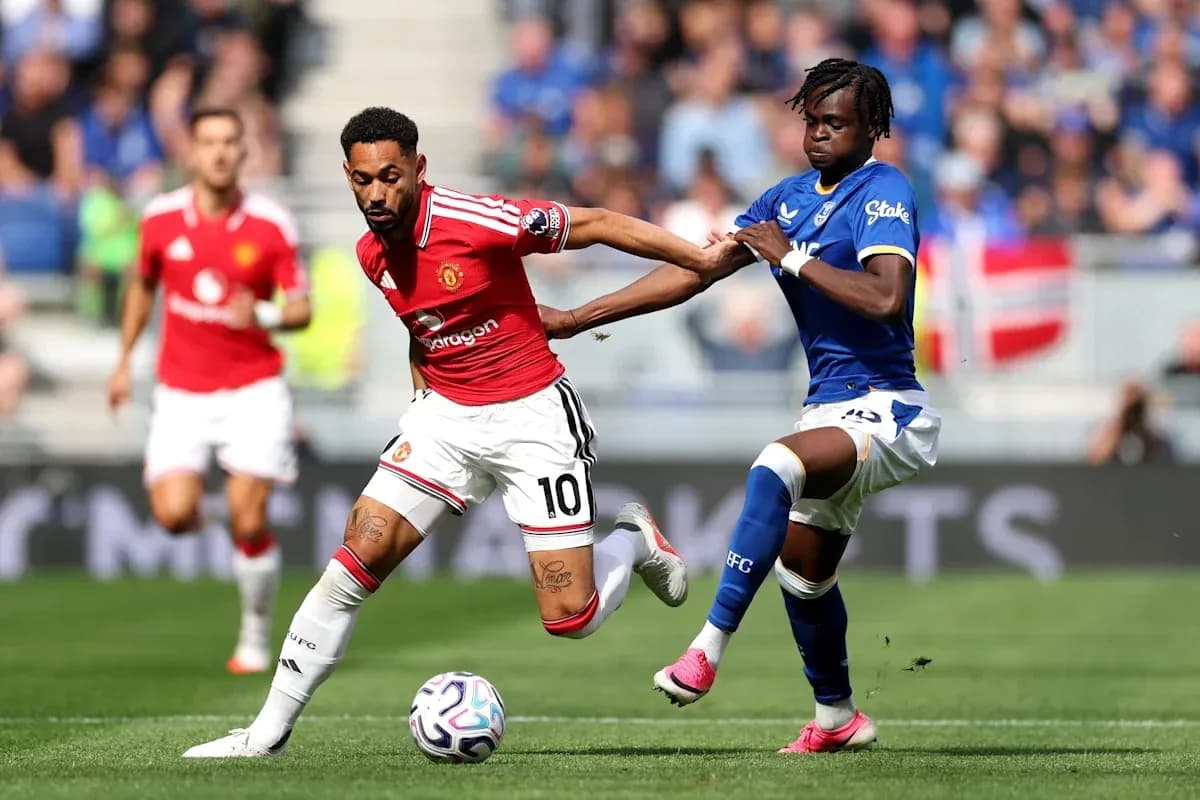 Joueur de Manchester United dribblant sous pression d'Everton