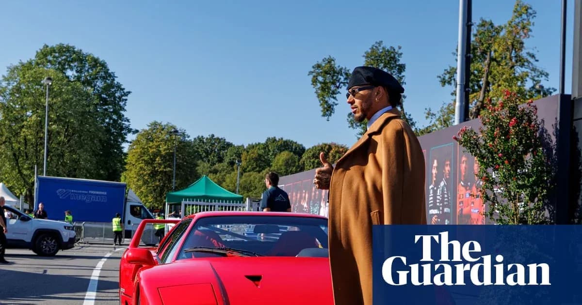 Homme en manteau près d'une voiture rouge
