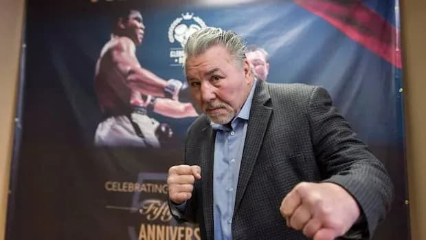 Homme faisant un geste de boxe devant une affiche