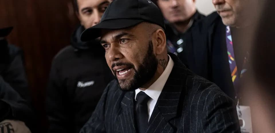 Person en costume parlant à un groupe de journalistes