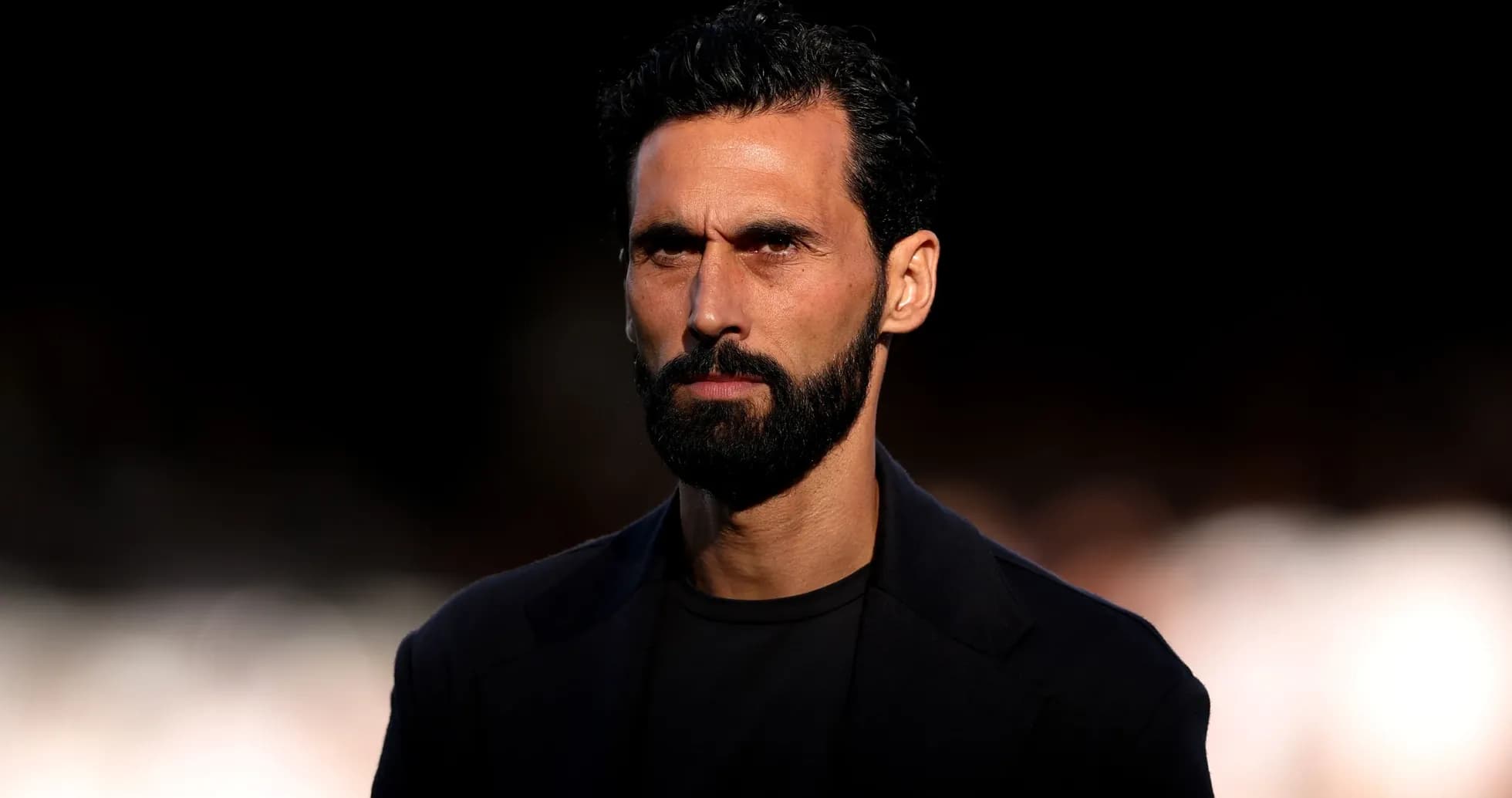 Homme avec barbe et cheveux noirs, regard sérieux