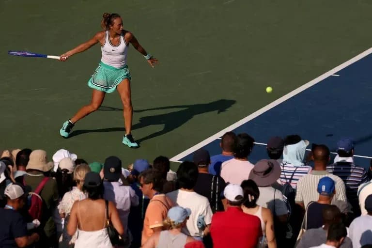 Joueuse de tennis frappant une balle devant un public