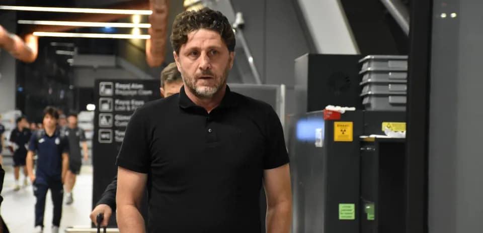 Homme marchant dans un hall d'aéroport avec une valise