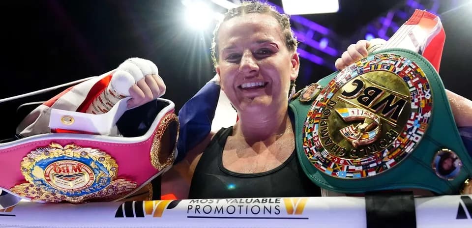 Boxeuse souriante tenant deux ceintures de championne