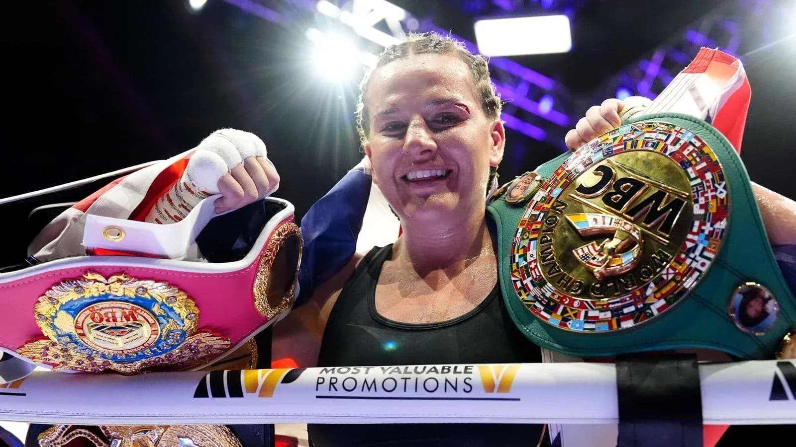 Boxeuse souriante tenant deux ceintures de championne