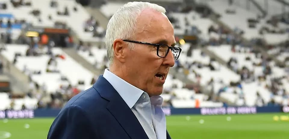 Homme en costume parlant sur le terrain de football