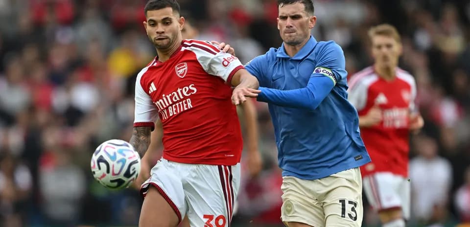 Joueur d'Arsenal dribblant sous la pression adverse