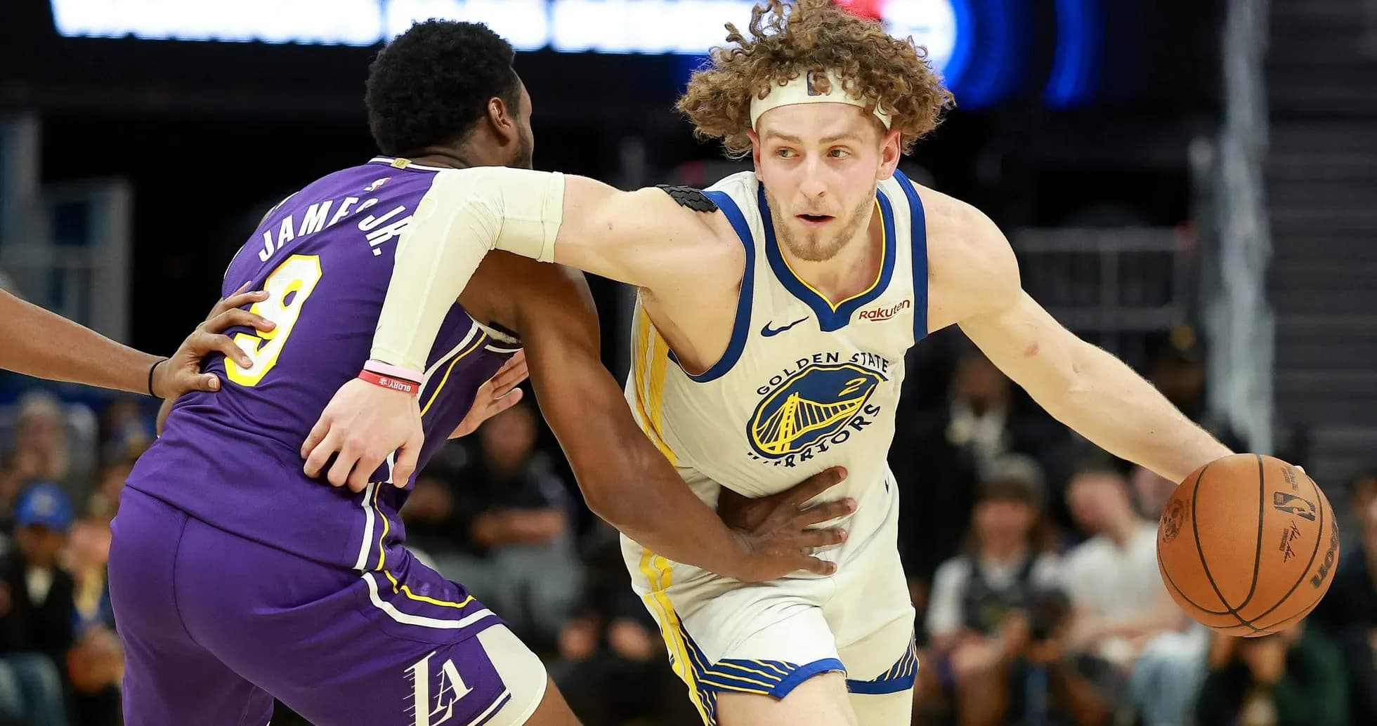 Joueur des Warriors dribblant sous pression d'un adversaire