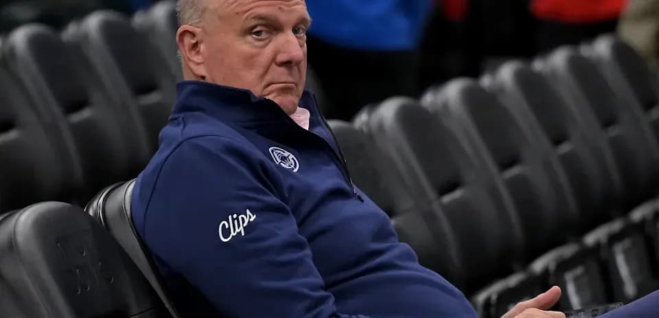 Person assis dans un stade, portant un pull bleu
