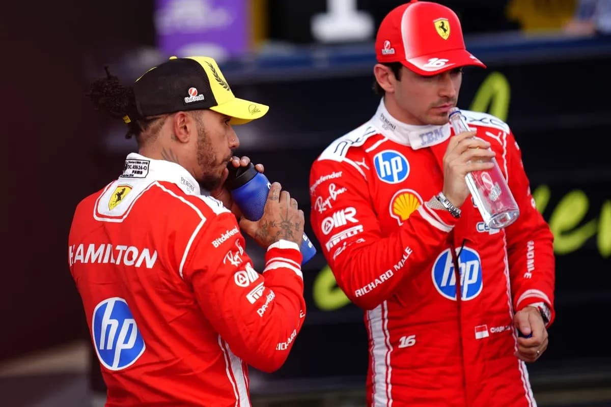 Deux pilotes en tenue Ferrari buvant de l'eau