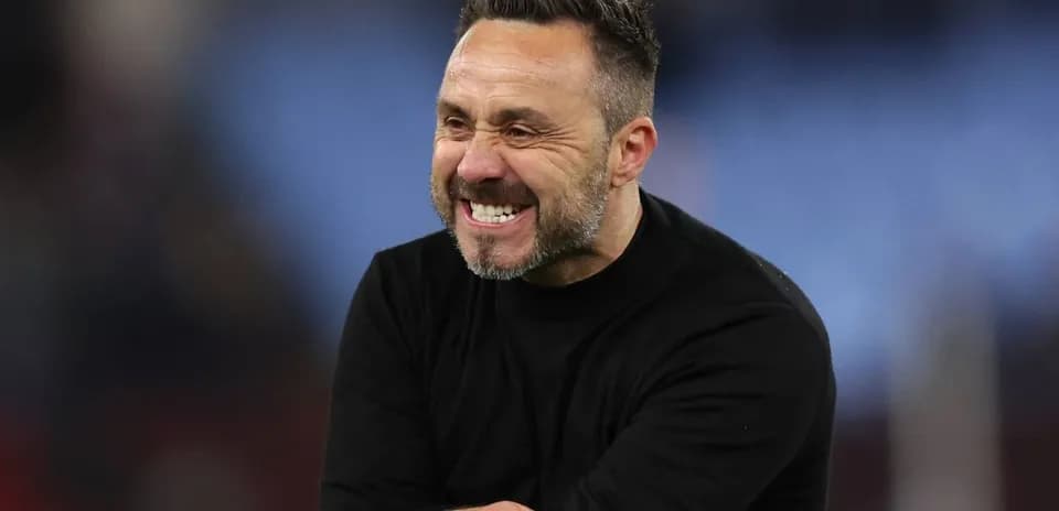 Entraîneur souriant sur le terrain après le match
