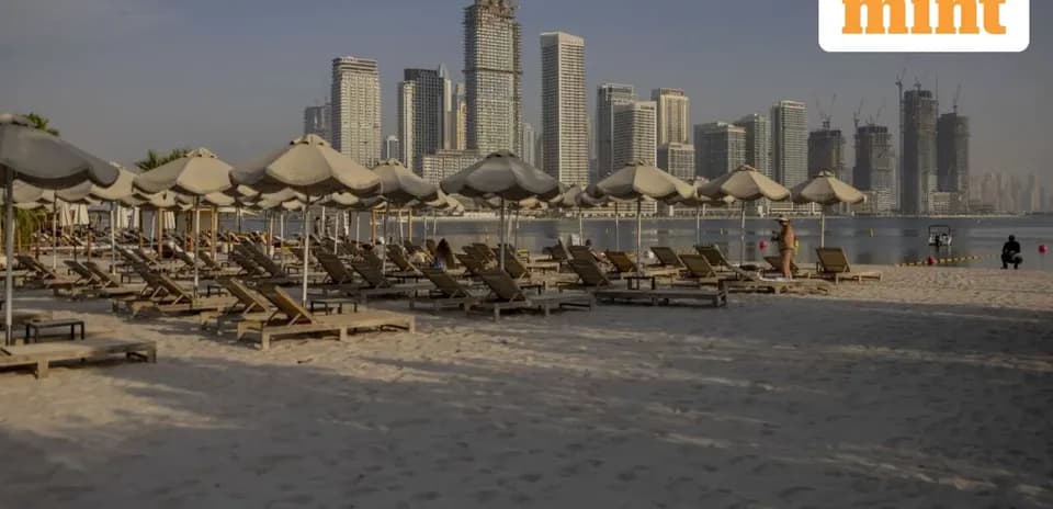 Plage avec chaises longues et gratte-ciels en arrière-plan