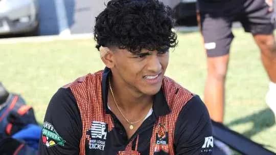 Jeune joueur de cricket assis sur le terrain