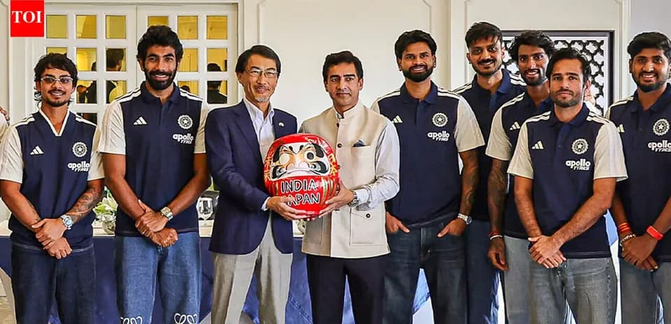Joueurs indiens posant avec une poupée Daruma