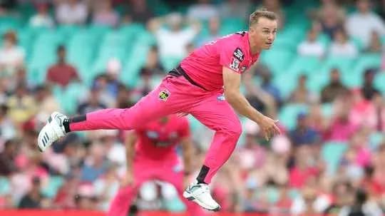 Joueur lançant la balle lors d'un match de cricket