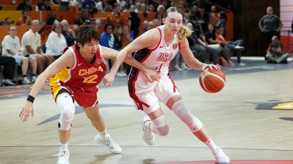 Joueuse des États-Unis dribblant le ballon, poursuivie par une adversaire