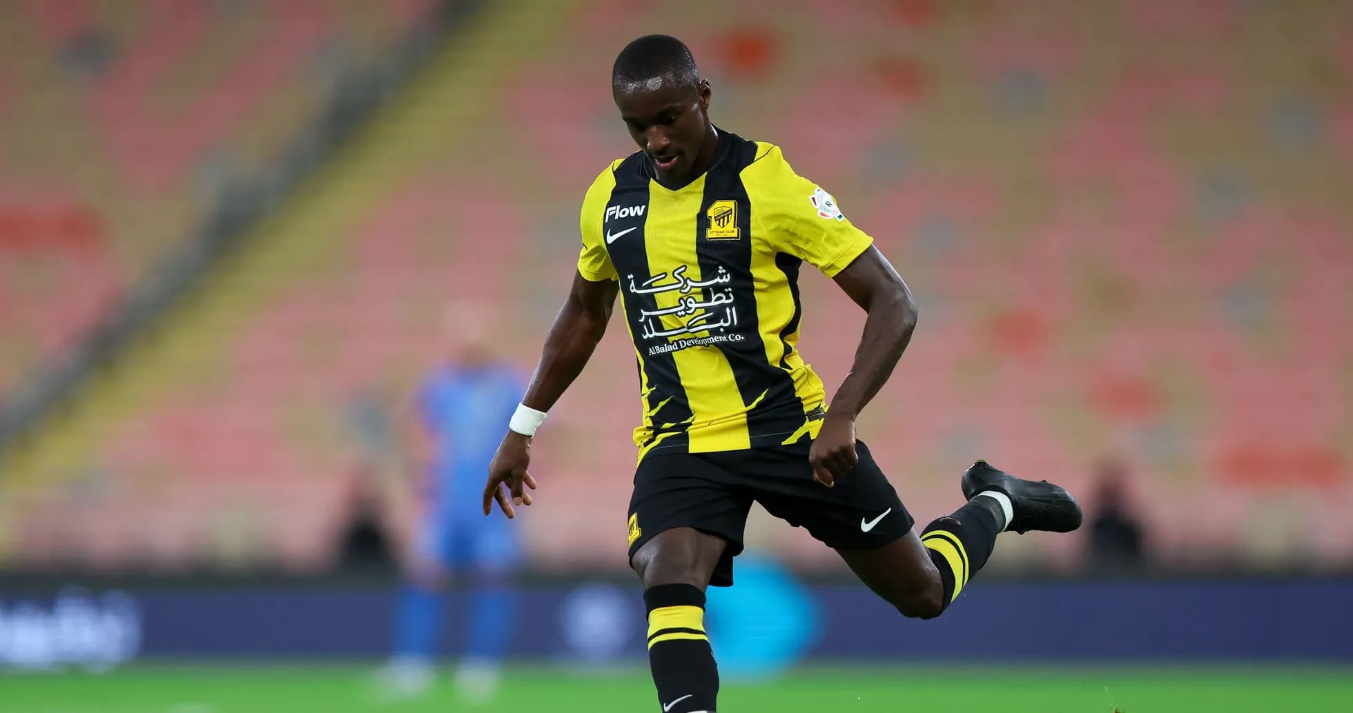 Joueur dribblant le ballon sur le terrain de football