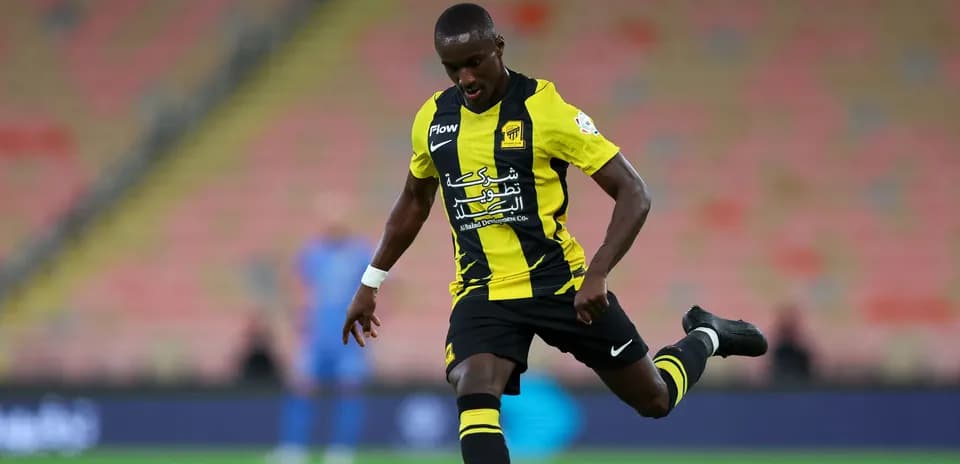Joueur dribblant le ballon sur le terrain de football
