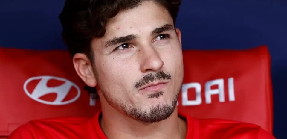 Joueur assis sur le banc de touche en maillot rouge
