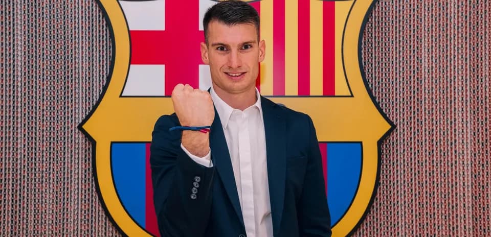 Joueur posant avec poing fermé devant le logo du FC Barcelone