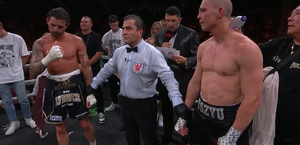Boxeurs et arbitre après le combat sur le ring
