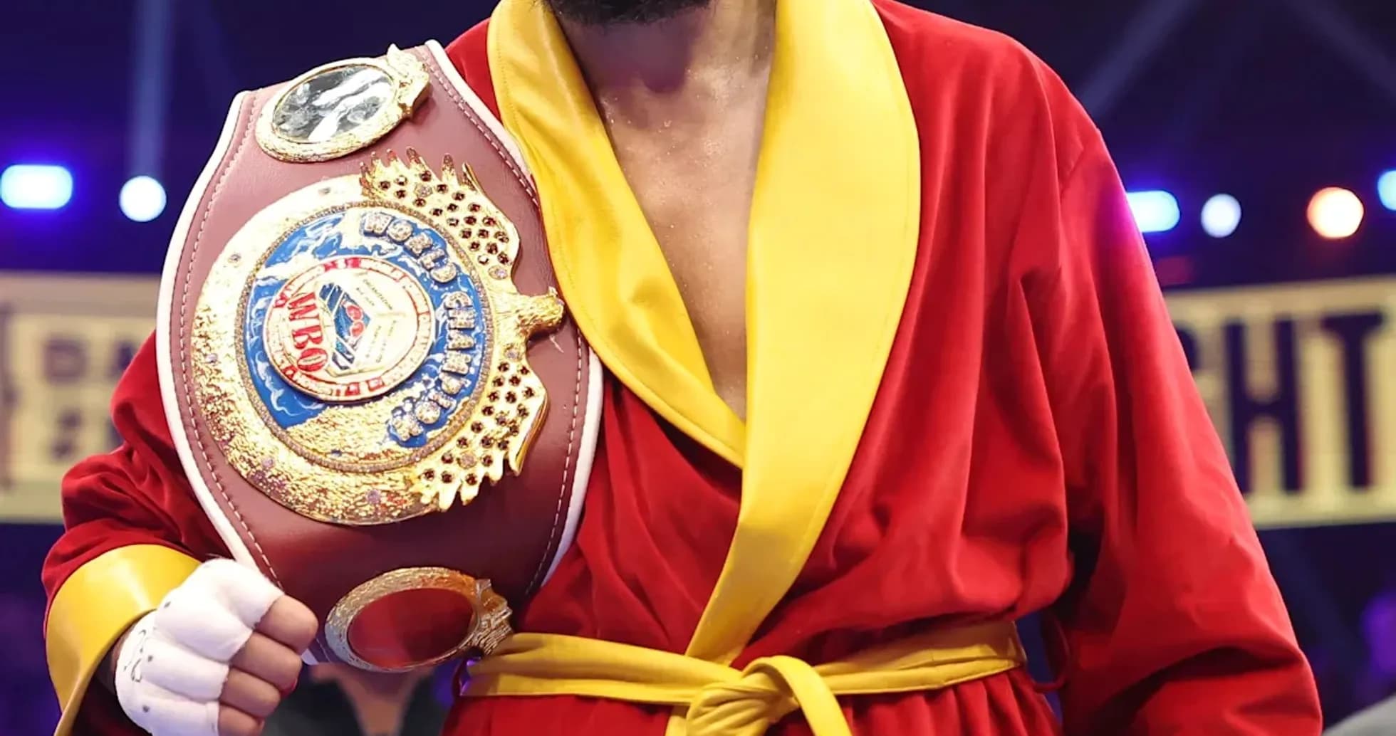 Boxeur en robe rouge tenant un ceinture de champion