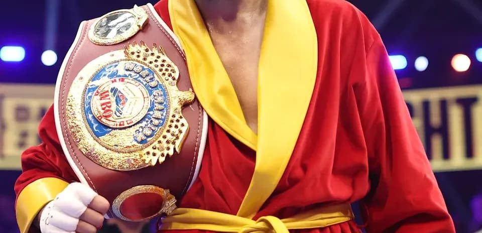 Boxeur en robe rouge tenant un ceinture de champion