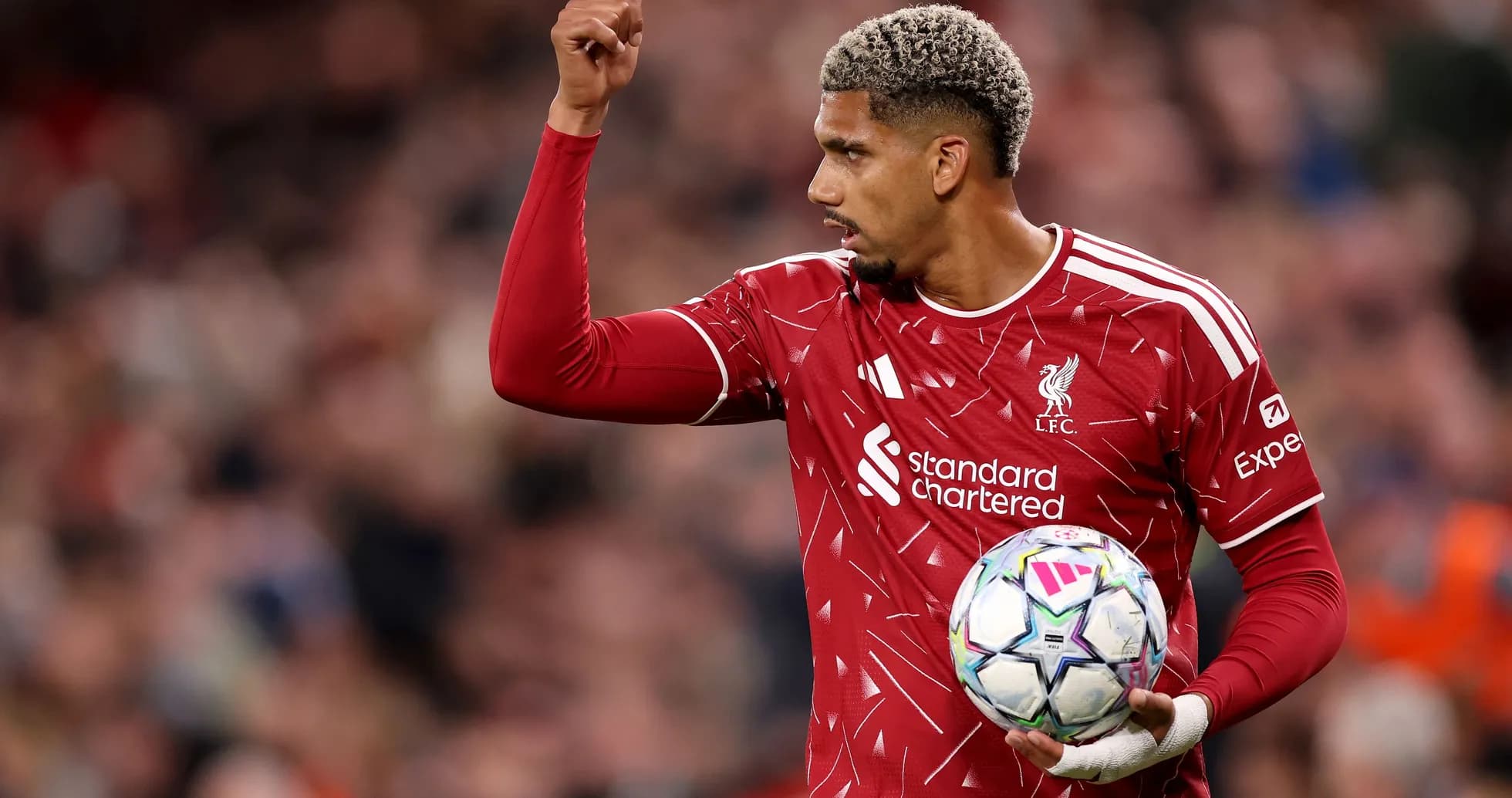 Joueur de Liverpool levant le bras avec le ballon