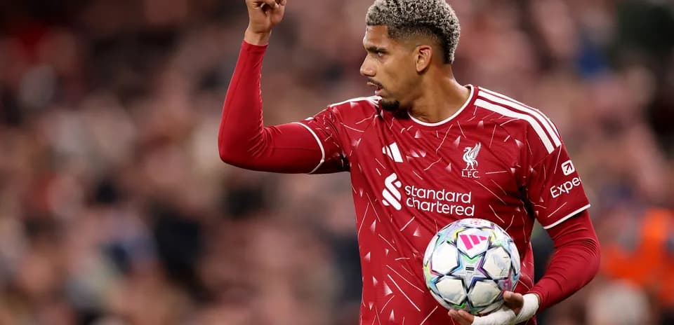 Joueur de Liverpool levant le bras avec le ballon