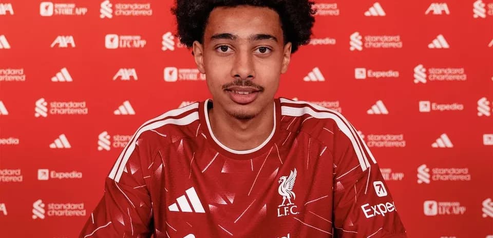 Joueur de Liverpool signant un contrat à la table