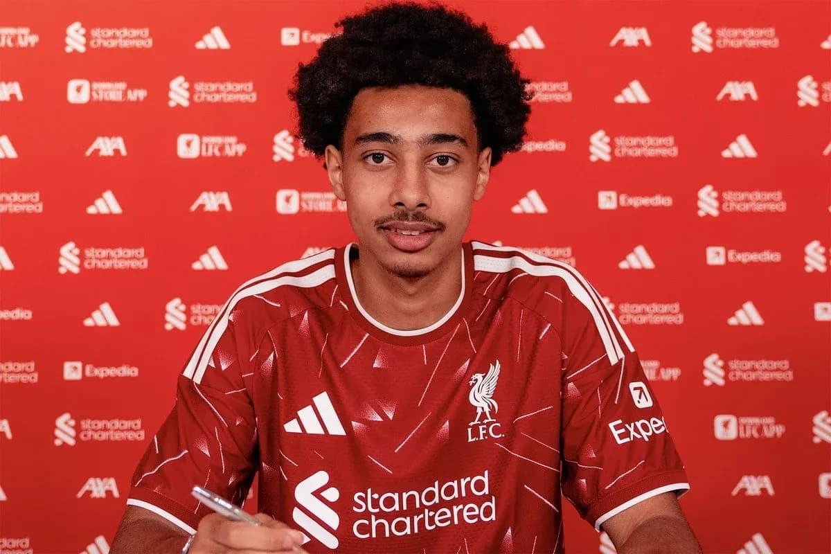 Joueur de Liverpool signant un contrat à la table