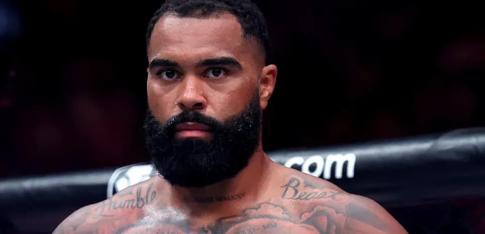 Combattant de MMA avec barbe et tatouages, regard sérieux