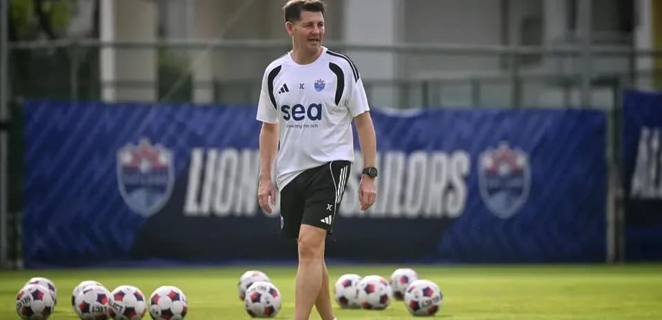 Entraîneur sur le terrain avec des ballons de football