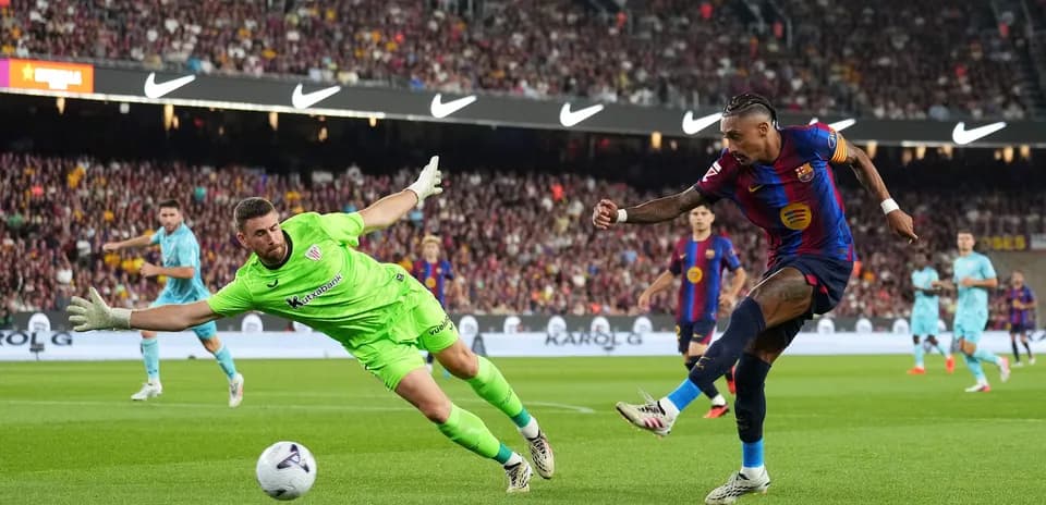Joueur du Barça tirant au but, gardien plongeant