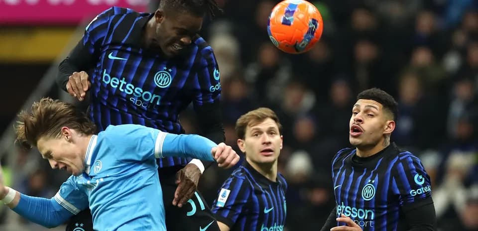 Joueur de l'Inter en duel aérien avec un adversaire