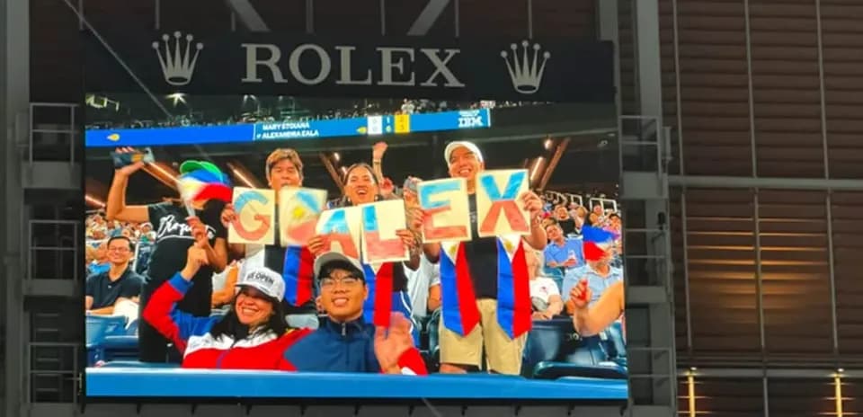 Supporters holding 'GO ALEX' sign at event