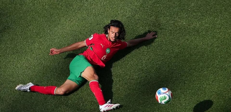 Joueur marocain étendu sur le terrain avec ballon