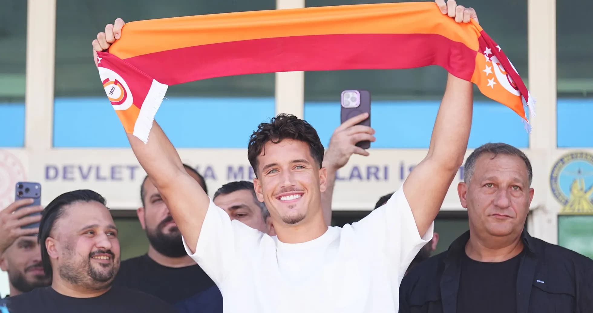 Joueur tenant une écharpe de Galatasaray lors d'une présentation