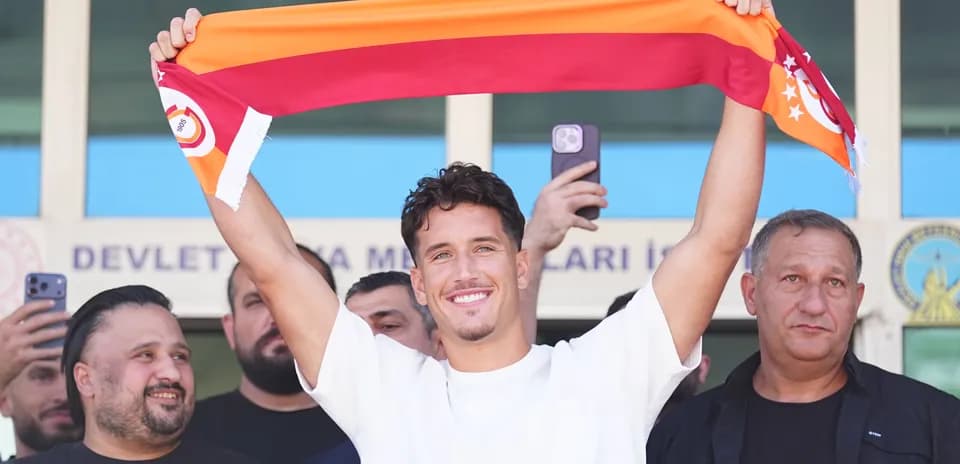 Joueur tenant une écharpe de Galatasaray lors d'une présentation