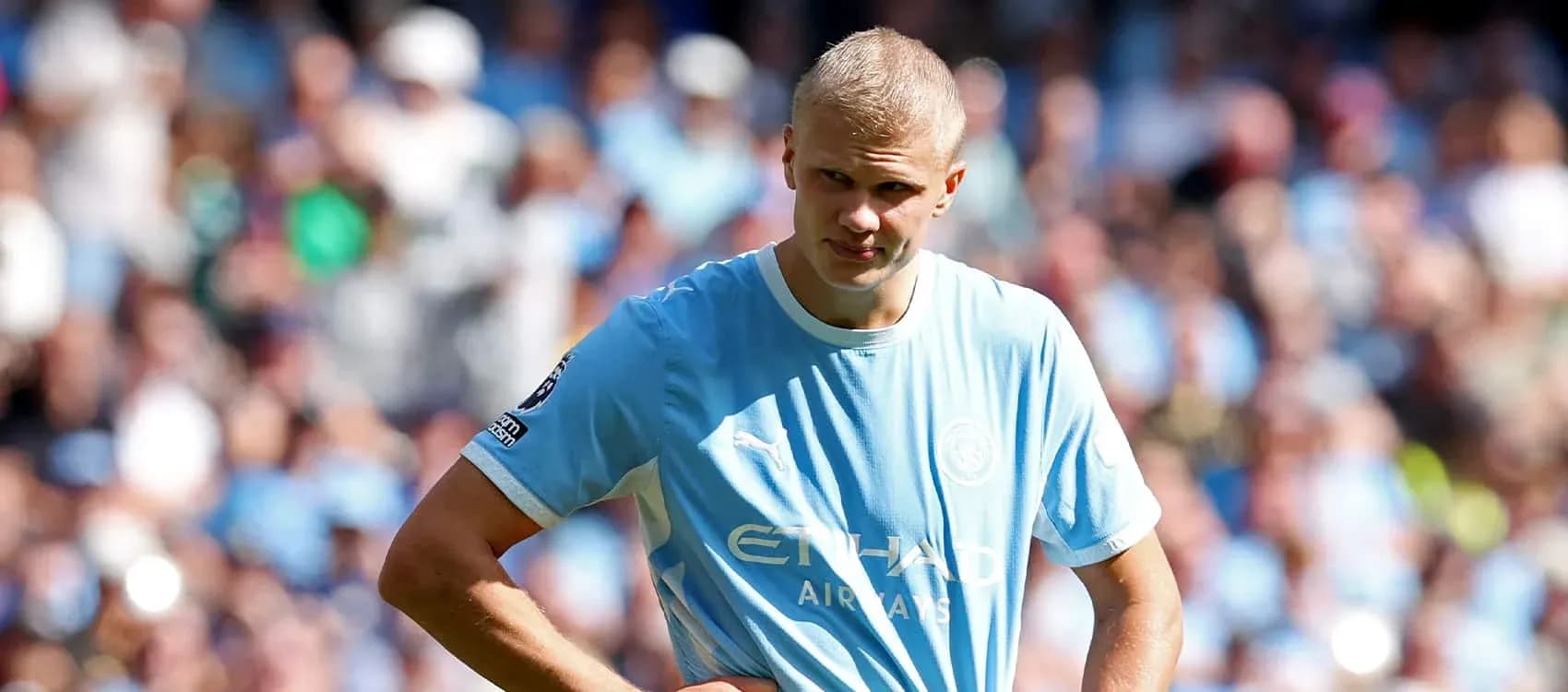Joueur de Manchester City sur le terrain avec foule en arrière-plan