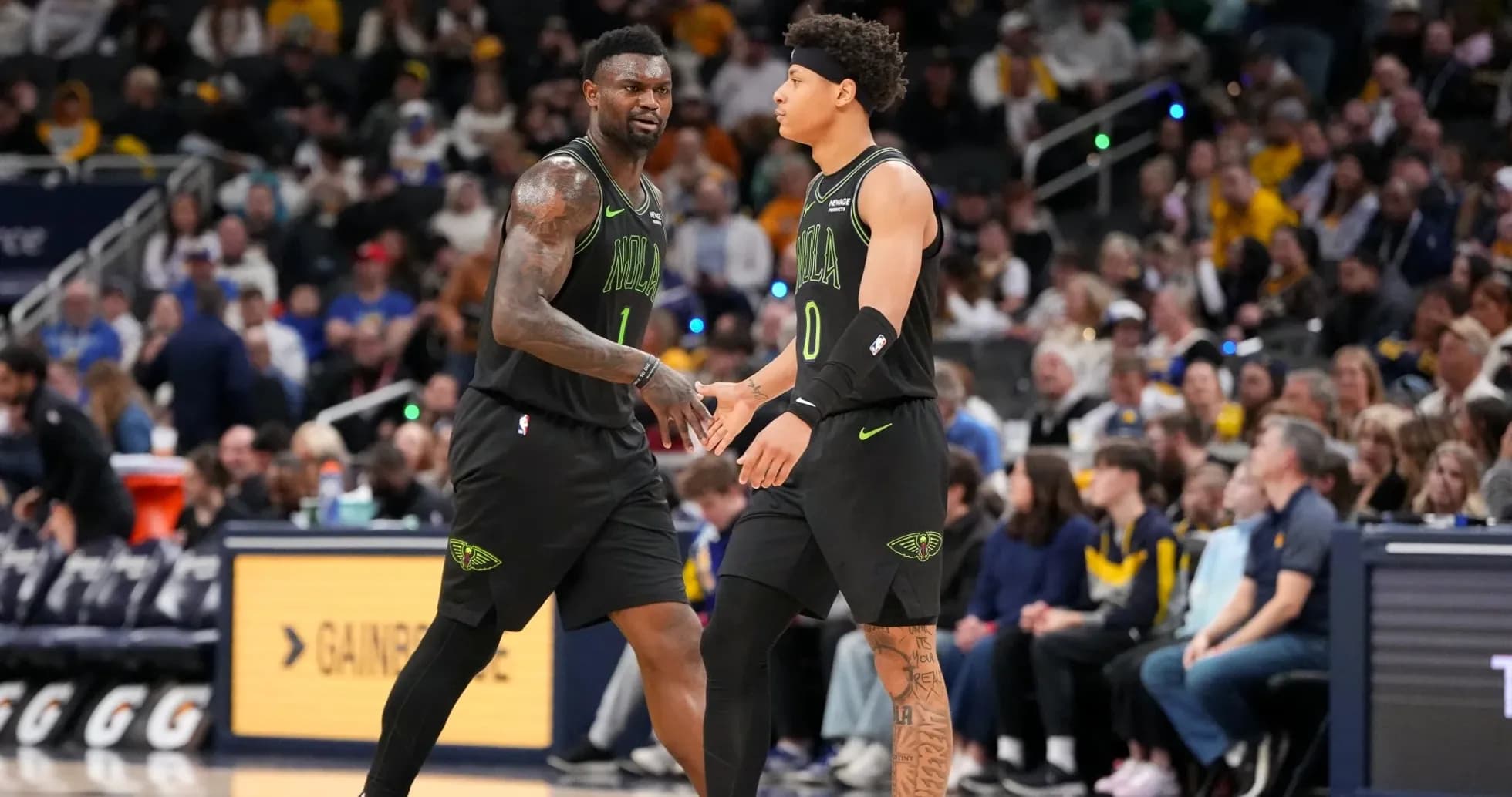 Deux joueurs de basket échangeant un high five sur le terrain