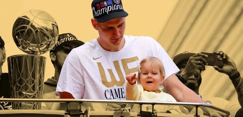 Joueur tenant un enfant près du trophée NBA