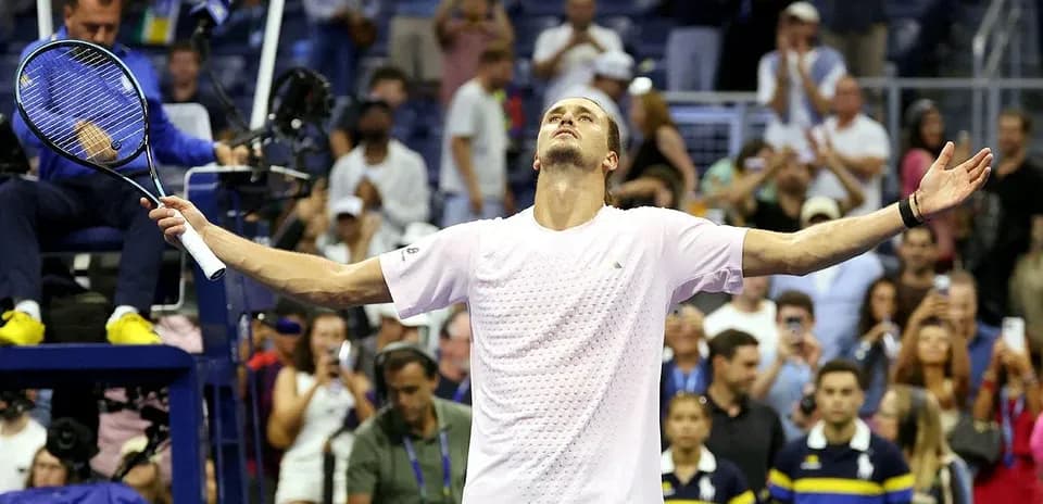 Joueur levant les bras après une victoire au tennis
