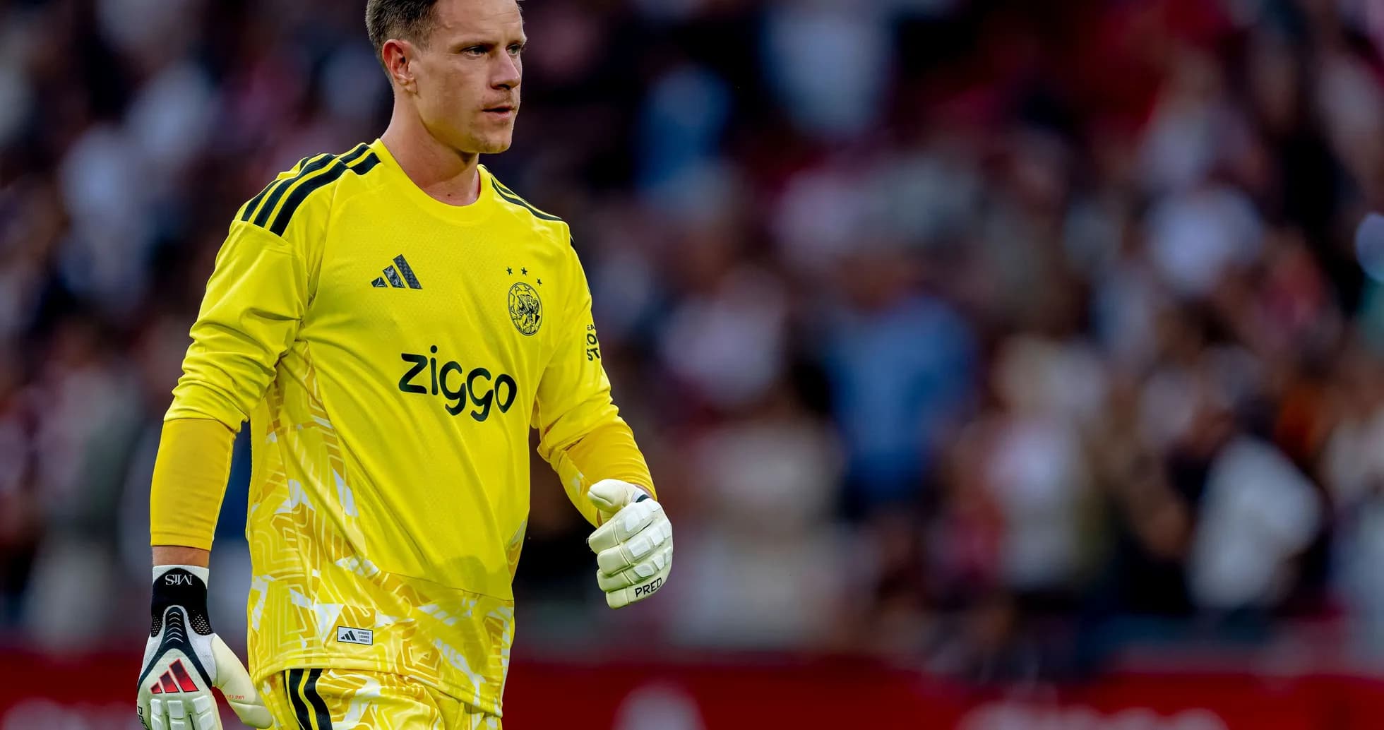 Gardien de but d'Ajax en maillot jaune sur le terrain