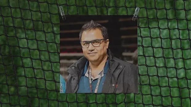 Homme souriant portant des lunettes et une veste